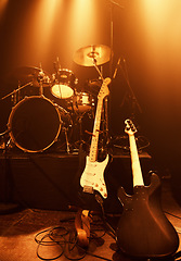 Image showing Instruments, guitar and drums for band at stage for concert and performance of music with talent. Electric, equipment and creativity in theater with spotlight for show at night with no people