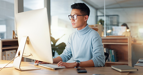 Image showing Asian man at computer, glasses and ideas, thinking and reading email, web review or article at digital agency. Research, reflection and businessman at tech startup networking on business website.