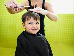 Image showing Child, boy and hairdresser with haircut at salon for grooming, hairstyle and grimace with scissors and comb. Barber, person and kid for hair treatment, haircare and hairstyling with cutting and happy