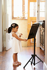 Image showing Flute, girl and child playing in home for learning, education and reading music sheet to practice performance. Art, flutist and kid with talent, creative or hobby with instrument for sound at lesson