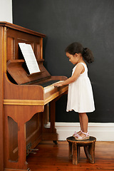 Image showing Piano, stool and kid in home for learning, practice and classical education with musical notes. Training, melody and student with talent, creative or hobby with instrument, child development or skill