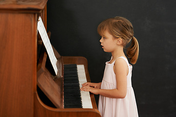 Image showing Piano, reading and kid in home for learning, practice and classical education with musical notes. Training, melody and girl with talent, creative or hobby with instrument, child development or skill