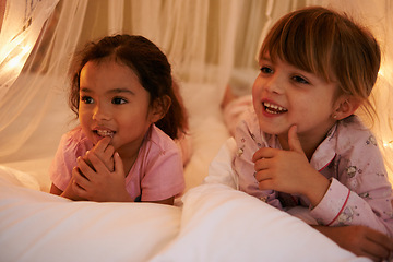 Image showing Happy, lights and children at night in bedroom for resting, relaxing and dreaming in home. Sleepover, sibling and young girls with fairy light decoration on bed for fantasy, magic and childhood