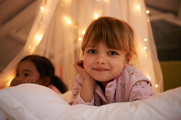 Image showing Bedroom, lights and portrait of children at night for resting, relaxing and dreaming in home. Happy, smile and face of young girls with fairy light decoration on bed for fantasy, magic and childhood