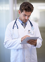 Image showing Research, tablet and doctor in hospital for medical information on the internet for diagnosis. Reading, professional and male healthcare worker with telehealth on digital technology in clinic.