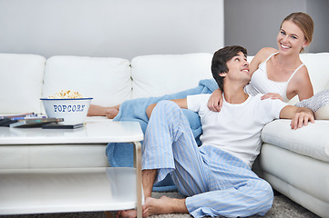 Image showing Couple, film and lying with living room, popcorn and sofa for relaxation and love or smile. People, home and romance for comfortable valentines day date and happiness for video or streaming movie