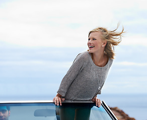 Image showing Happy, blue sky and convertible car with woman on road trip for travel, vacation or holiday in summer. Space, smile and journey with young person driving in vehicle for transport in fresh air