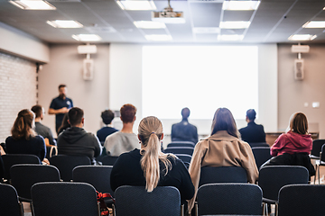 Image showing Speaker giving a talk in conference hall at business event. Rear view of unrecognizable people in audience at the conference hall. Business and entrepreneurship concept.