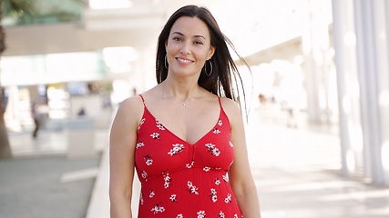 Image showing Smiling Woman in Red Dress Strolling in Sunny Spain