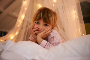 Image showing Bedroom, lights and portrait of child at night for resting, relaxing and dreaming in home. Happy, smile and face of young girl with fairy light decoration on bed for fantasy, magic and childhood