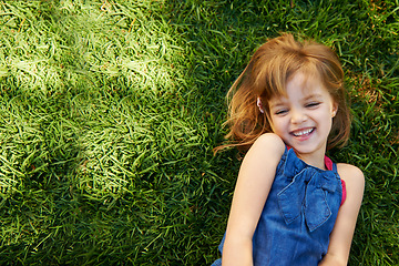 Image showing Child, grass and smile from above for relax holiday in countryside for summer vacation, nature or park. School kids, and happy on garden lawn in California environment for outdoor, sunshine or mockup