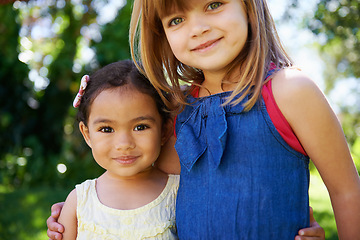 Image showing Portrait, children and smile for play date in garden, park or forest on sunny day in New Zealand. Happy, girls or adopted sisters for hug in friend diversity or family photo in Spring or summer