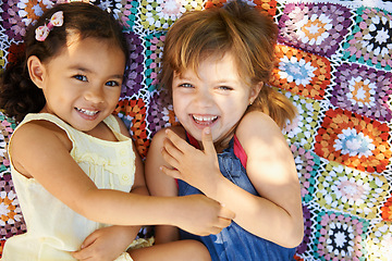 Image showing Happy, nature and girl children on blanket playing together in outdoor park or garden on vacation. Smile, bonding and high angle portrait of young kid friends relaxing in field on holiday or weekend.