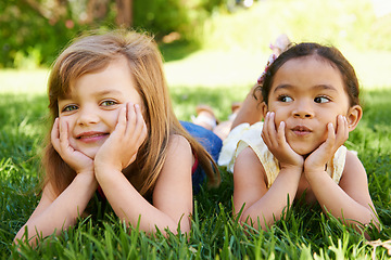 Image showing Smile, nature and portrait of children on grass playing together in outdoor park or garden on vacation. Happy, bonding and young girl kid friends relaxing on lawn in field on holiday or weekend.