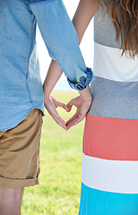 Image showing Love, summer and heart hands with couple outdoor in garden, park or yard together for date from back. Emoji, peace or trust with man and woman in nature or environment for bonding and affection