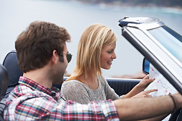 Image showing Map, travel and couple in a car for transportation to vacation, adventure or holiday destination. Reading, navigating guide and people on journey in vehicle driving for weekend road trip together.