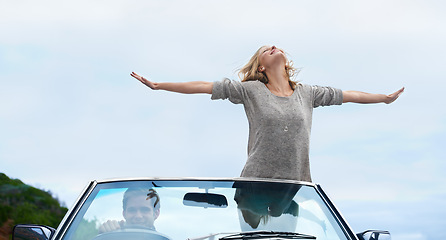 Image showing Man, driving and convertible or woman freedom with arms up on road trip for travel adventure, journey or explore. Couple, happy and together in California for weekend holiday or date, vacation or joy