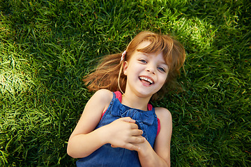 Image showing Child, portrait and grass with smile or above for relax holiday in countryside for summer vacation, nature or park. School kids, face and happy in California environment for laugh, sunshine or meadow