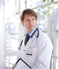 Image showing Thinking, clipboard and man doctor in hospital with medical chart for diagnosis or treatment. Brainstorming, checklist and mature male healthcare worker with documents in medicare clinic corridor.