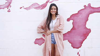 Image showing Stylish Woman Standing Against a Pink Paint Splash Wall