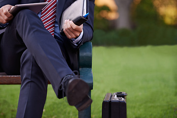 Image showing Closeup, tablet and business man on bench, park and planning with lunch break and professional. Employee, outdoor and consultant with suitcase and technology for ideas and shoes with fashion or relax