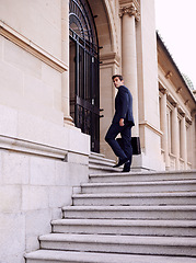 Image showing Business, briefcase and man walking into law firm in city with evening commute, stairs and court building. Businessman, lawyer or attorney on outdoor steps with formal bag for urban travel from work