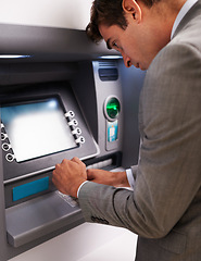 Image showing Businessman, ATM and typing pin for cash withdrawal, security or privacy in financial safety at money machine. Man in business suit on electronic banking system for deposit, investment or finance