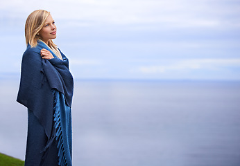 Image showing Thinking, ocean and woman with blanket on mountain for adventure on holiday, vacation and weekend outdoors. Nature, travel and person by seaside for relaxing, happiness and peace in countryside