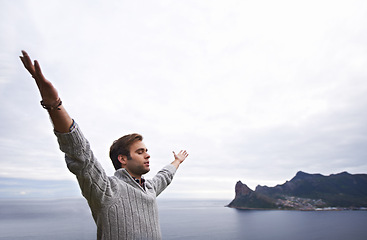 Image showing Freedom, mountain and man by ocean with eyes closed for adventure on holiday, vacation and weekend. Nature, travel and happy person by seaside for relaxing, outdoors and inspiration in countryside