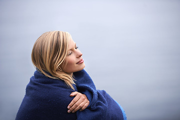 Image showing Closeup, woman and outdoor with blanket for holiday with smile, wellness and contemplate for leisure. Vacation, reflect with memories in nature for happiness, relax and healthy mindset with trip