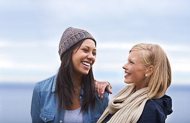 Image showing Friends, happy and women by ocean laugh for adventure on holiday, vacation and weekend outdoors. Nature, travel and people talking by seaside for fun, relaxing and bonding together in countryside