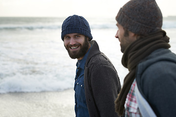 Image showing Travel, friends and smile with men at the beach for adventure, vacation and relax. Happy, calm and winter with people walking at seaside for holiday trip, nature and outdoor journey together