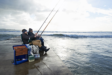 Image showing Friends, fisherman and men by ocean fishing with rod, reel and equipment to catch fish for hobby. Nature, sports and people cast a line for fun, relaxing or adventure on holiday, vacation and weekend