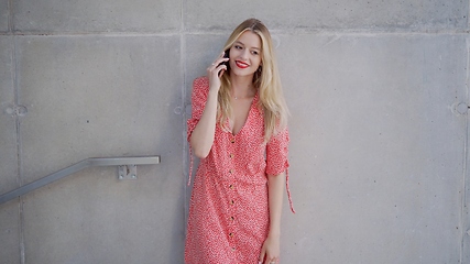 Image showing Stylish Woman in Red Dress Talking on Phone Outdoors