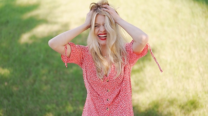 Image showing Joyful Woman Enjoying Sunny Day in Flowery Dress