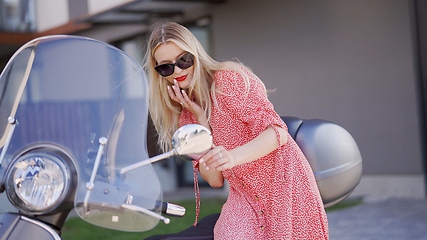 Image showing Fashionable Woman Leaning on a Vintage Scooter Outdoors