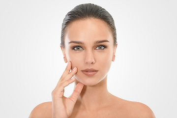 Image showing Girl, skincare and hand on face in studio for beauty with natural look, cosmetics and dermatology for wellness. Woman, portrait and clean for self care, mockup and white background with serious model