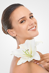 Image showing Makeup, beauty and woman with flower in studio with natural, glow and cosmetic face routine. Portrait, confident and young female person with floral plant for facial cosmetology by white background.