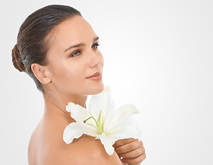 Image showing Makeup, flower and beautiful woman in studio with glamour, glow and cosmetic face routine. Beauty, mockup and young female person with floral plant for facial cosmetology by white background.