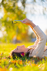 Image showing Woman, headphones and tablet for music on grass, streaming radio and podcast outdoors. Female person, nature and internet for movie subscription on weekend, calm and peaceful playlist on lawn