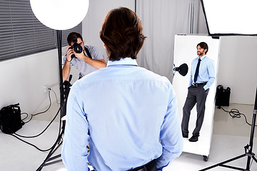 Image showing Photographer, model shoot and camera in studio, behind the scenes and equipment on set for advertising. Man, back and videographer with lens or gear for image, business marketing and corporate design
