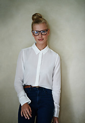 Image showing Portrait, young woman and fashion in blouse with spectacles and hair in a bun. Female person model with blonde up do with smart casual style clothes in studio as small business entrepreneur