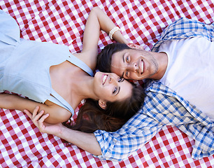 Image showing Happy, couple and blanket in portrait for picnic with love, connection and bonding on date from above. Man, woman and face with relax on ground for vacation, unity or holiday in relationship together