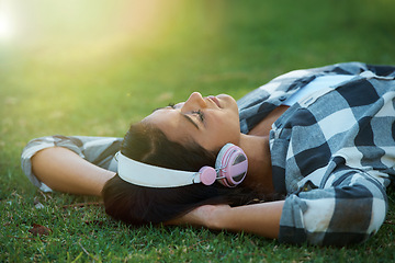 Image showing Music headphones, park or woman on lawn to relax for rest in garden, nature or field with smile or peace. Eyes closed, streaming or calm person on break with playlist for radio or podcast on grass