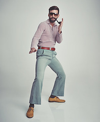 Image showing 70s, fashion and portrait of man with retro or vintage aesthetic in gray background of studio. Smoking, pipe and person dance with confidence in funky sunglasses and unique style from past or history