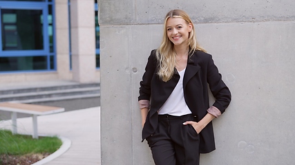 Image showing Confident Businesswoman Leaning Against Concrete Wall