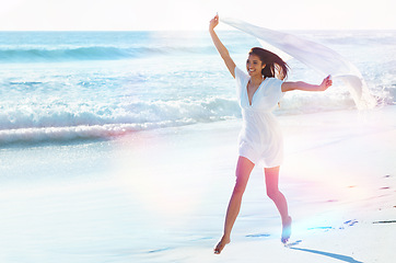 Image showing Woman, beach and happy with fabric in wind for freedom, adventure or running with smile in nature by sea. Girl, person and excited with sarong on holiday, vacation or waves in lens flare in Indonesia