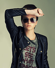 Image showing Woman, studio and punk with confidence, pose and sunglasses for gen z, trendy and fashion. Female rocker, leather jacket and contemporary for expression, tough and edgy portrait with individuality