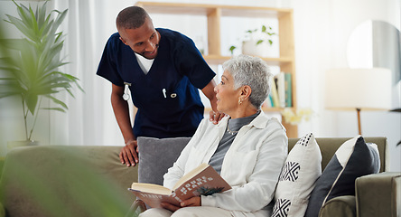 Image showing Elderly, woman and nurse on sofa with support, conversation and caregiver in living room of retirement home. Senior, person and man with kindness, happiness and discussion while reading a book