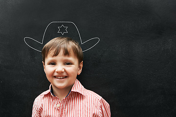 Image showing Boy, portrait and chalk with cowboy hat on board with smile in class, school and drawing for young skill development. Kid, blackboard and creativity for learning, education and growth with happiness